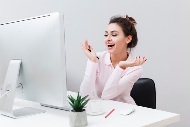 Front view of smiley woman looking at computer