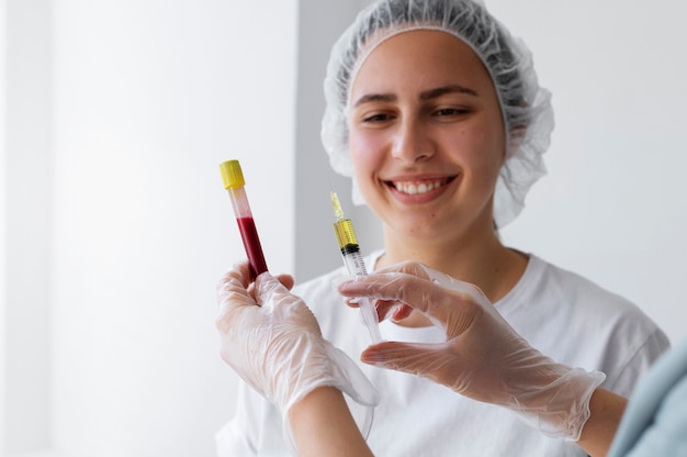 Front view smiley woman looking at injection