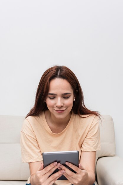 Front view of smiley woman looking at tablet