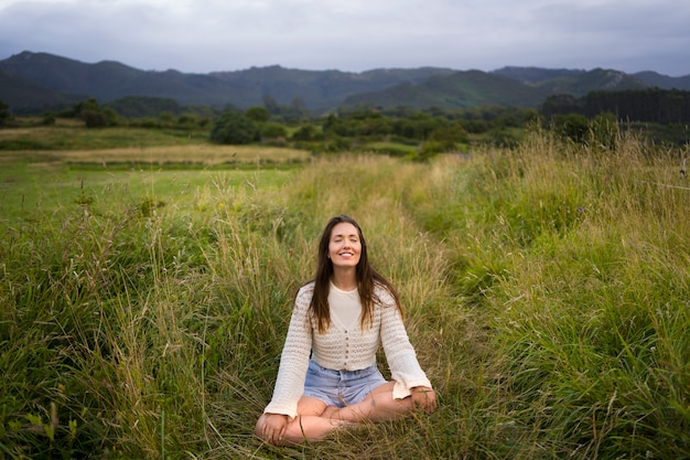 Free photo front view smiley woman meditating