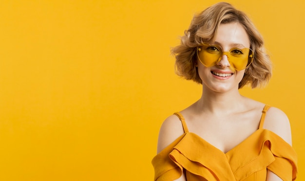 Front view of smiley woman poising while wearing sunglasses