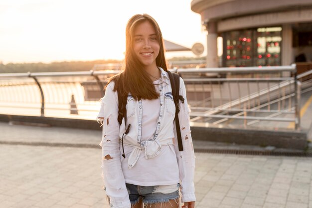 Front view of smiley woman posing while traveling alone