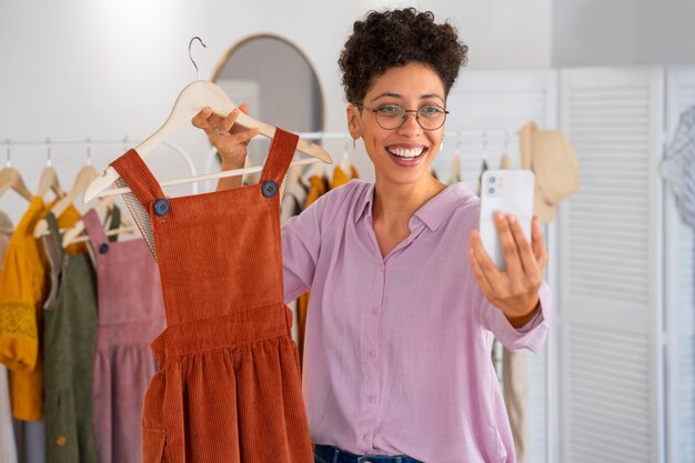 Front view smiley woman presenting clothes