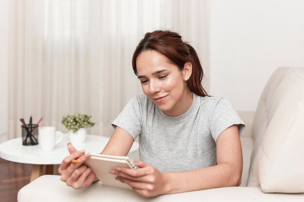 Free photo front view of smiley woman reading something from notebook