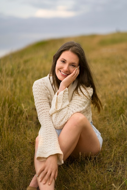 Front view smiley woman sitting outdoors