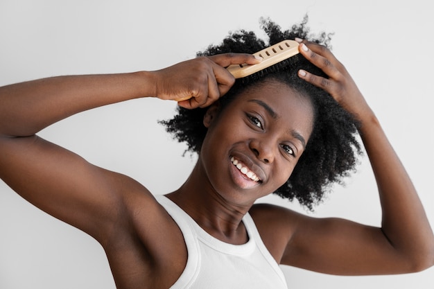 Foto gratuita donna sorridente di vista frontale che disegna i capelli