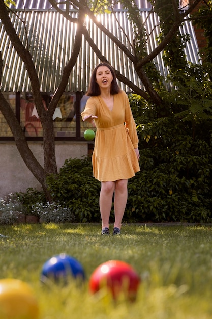 Free photo front view smiley woman throwing green ball