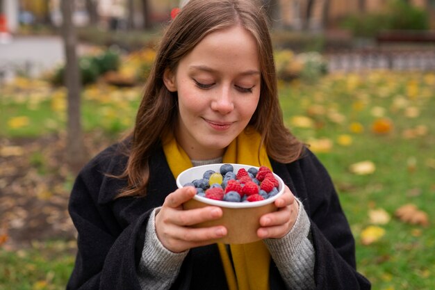 Front view smiley woman with berries outdoors