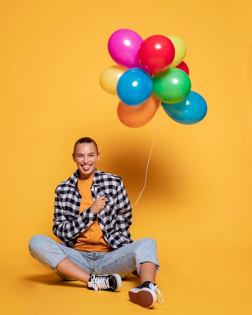 Front view of smiley woman with colorful balloons