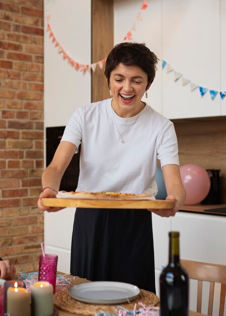 美味しいピザを持った笑顔の女性のフロントビュー