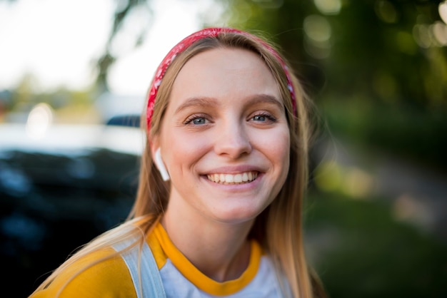 Front view of smiley woman with earbuds