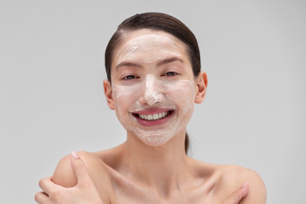 Foto gratuita donna sorridente di vista frontale con la maschera per il viso