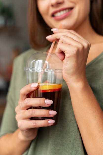 Foto gratuita donna sorridente vista frontale con kombucha