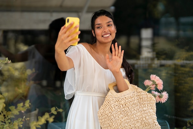 Free photo front view smiley woman with smartphone