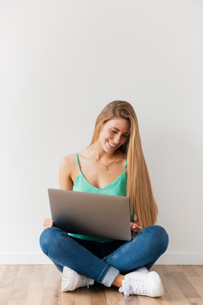Вид спереди смайлик женщина работает на ноутбуке