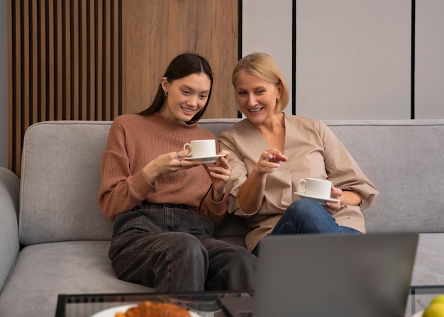 Foto gratuita donne di smiley di vista frontale che si siedono sul divano