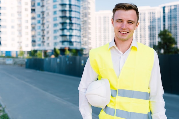 Free photo front view smiley young man with helmet