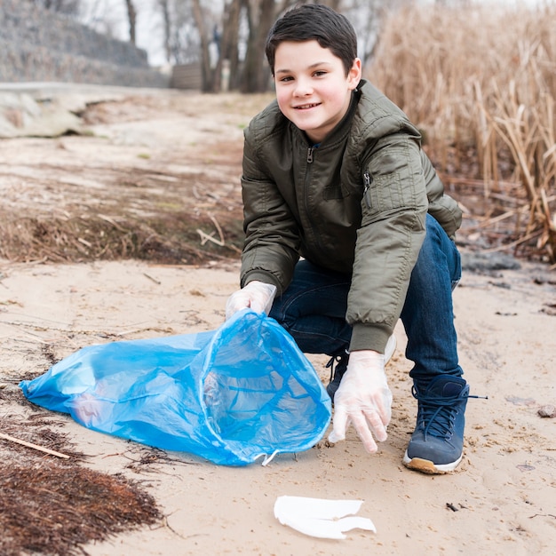 Free photo front view of smiling boy cleaning the ground