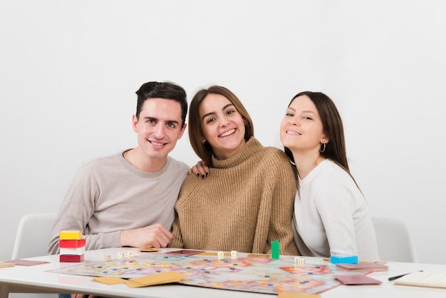 Free photo front view smiling friends playing a board game