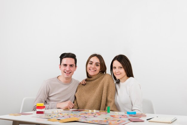 Front view smiling friends playing a board game