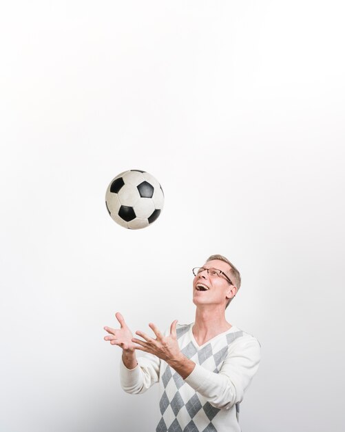 Front view of smiling man playing with a soccer ball