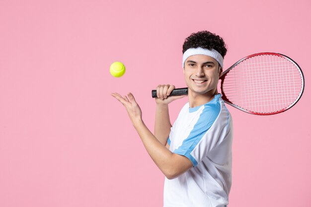 Front view smiling tennis player in sport clothes racket