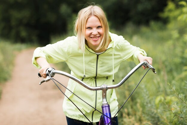 Front view smiling woman on bicycle