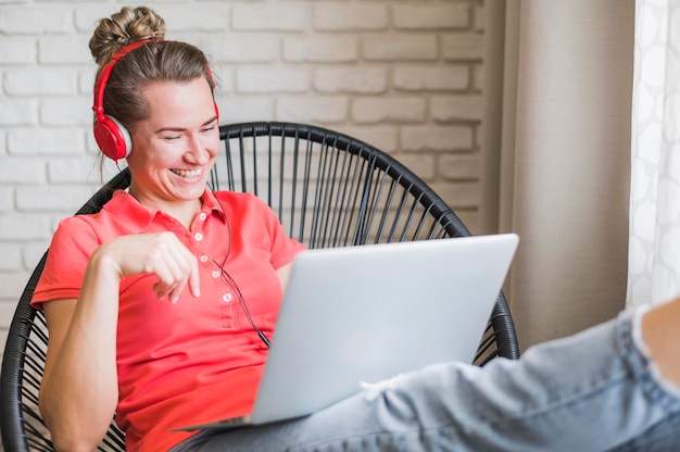 Front view of smiling woman listening music