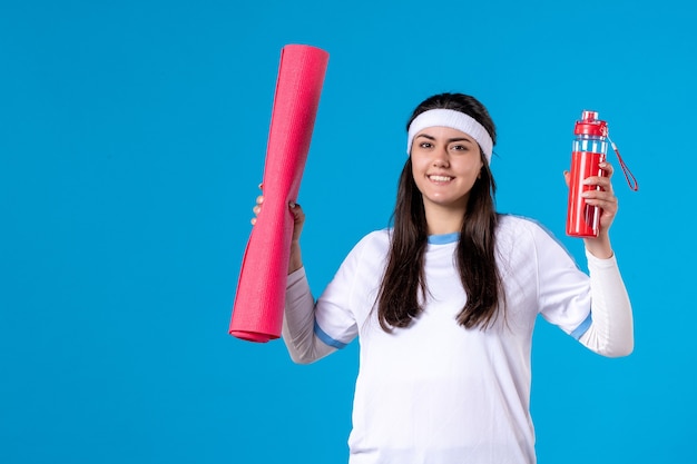 Front view smiling young female with yoga mat