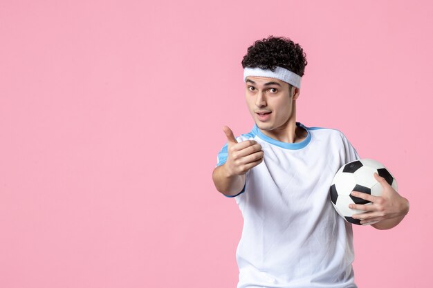 Front view soccer player in sport clothes with ball