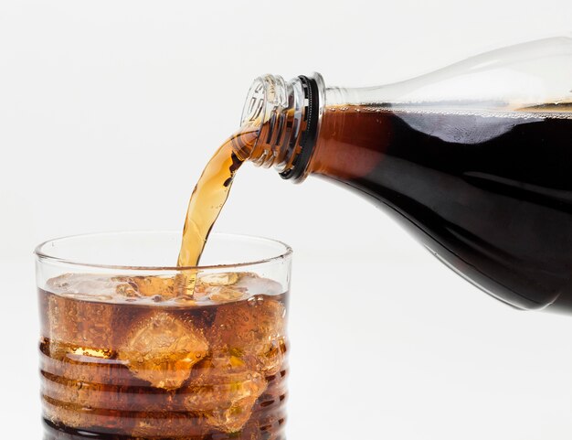 Front view of soft drink being poured in glass