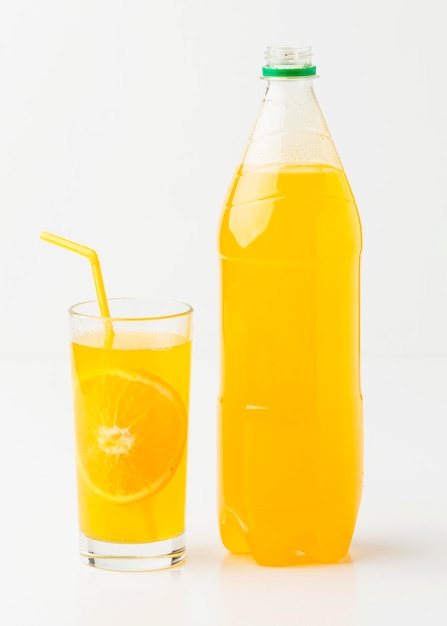 Front view of soft drink bottle with glass and straw