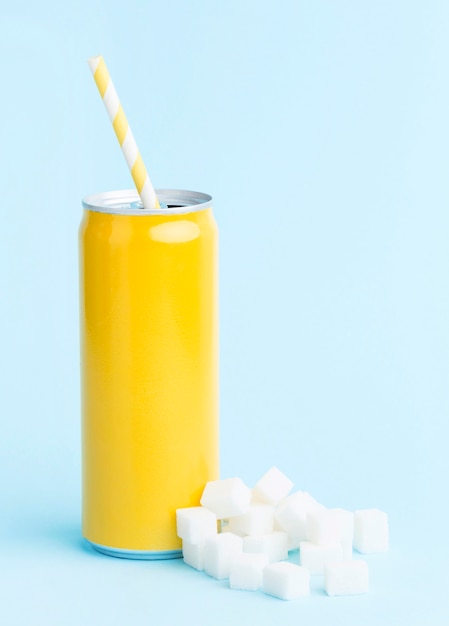 Front view of soft drink can with straw and sugar cubes