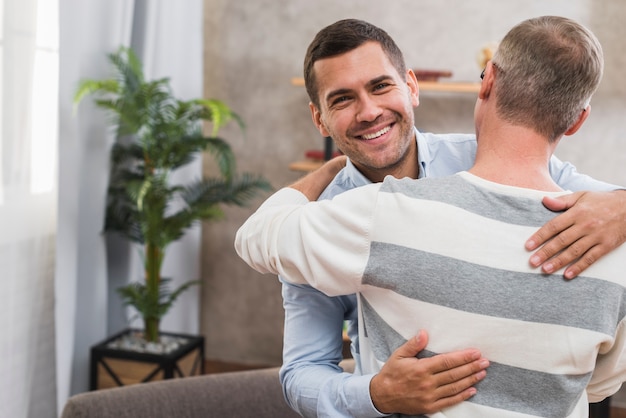 Free photo front view of son and father hugging