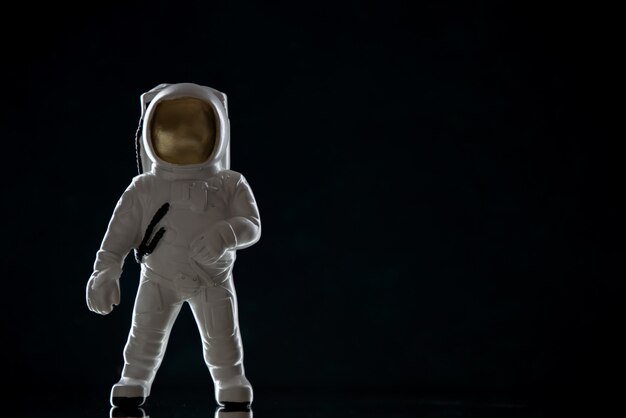 Вид спереди игрушки космонавта на черном