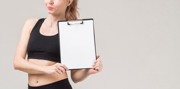 Front view of sporty woman holding notepad