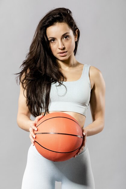 バスケットボールのボールでスポーティな女性の正面図