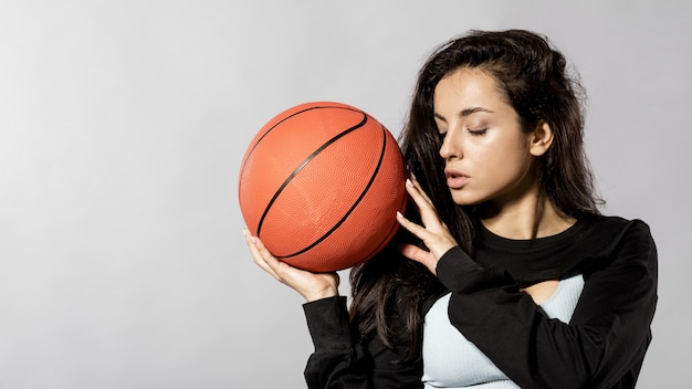 バスケットボールのボールでスポーティな女性の正面図