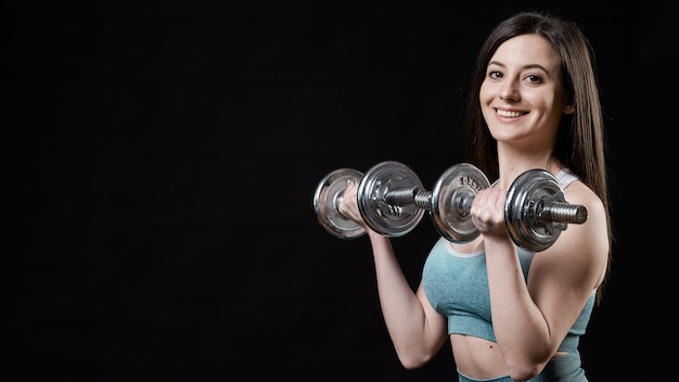 Front view of sporty woman with dumbbells