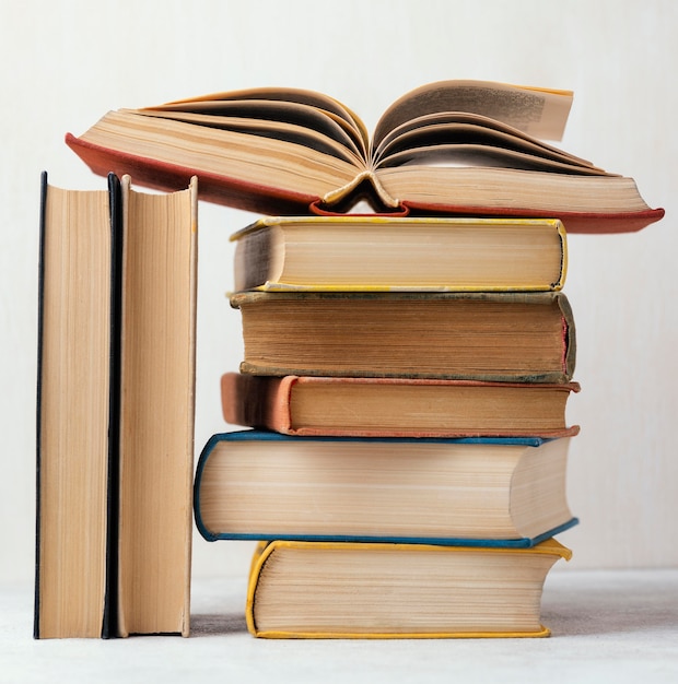 Free photo front view of stack of books with one open