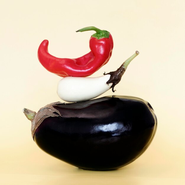 Free photo front view of stack of vegetables with eggplant and chili pepper