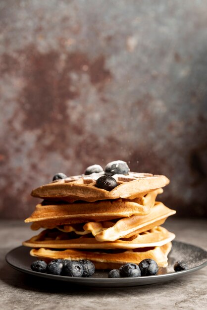 Front view of stack of waffles on plate with blueberries and copy space