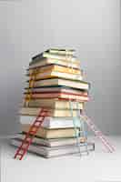 Free photo front view of stacked books and ladders with copy space for education day