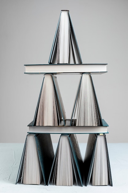 Foto gratuita libri impilati vista frontale con sfondo grigio