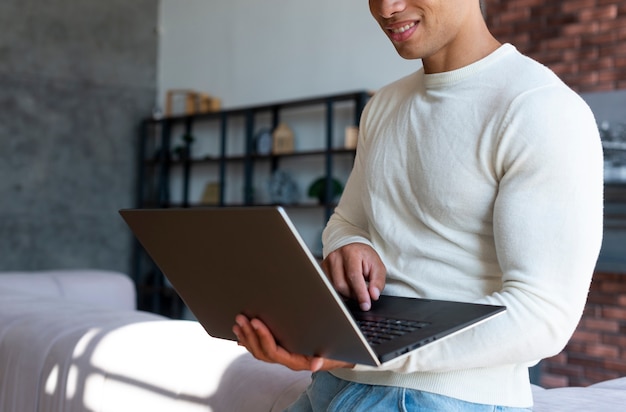 Front view of standing man using laptop
