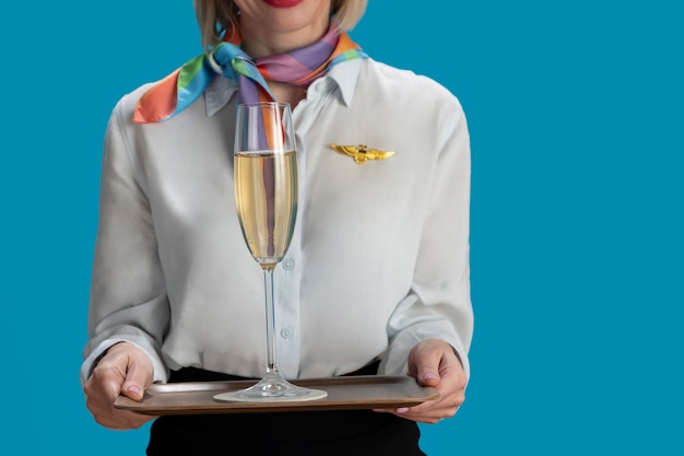 Free photo front view stewardess holding drink