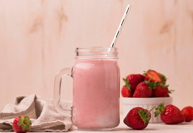 Front view of strawberry milkshake with straw