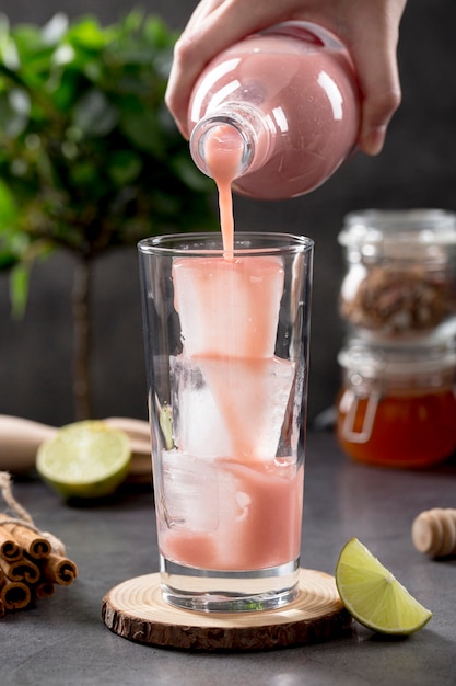 Front view strawberry smoothie being poured in glasses