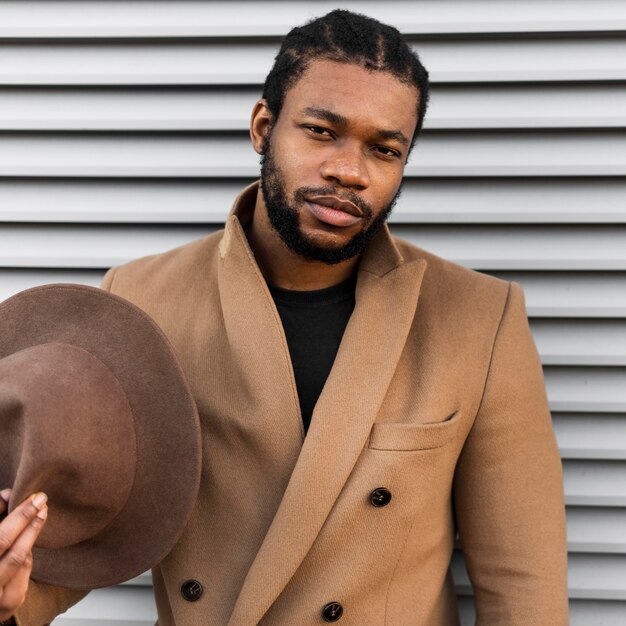 Front view stylish man holding his hat