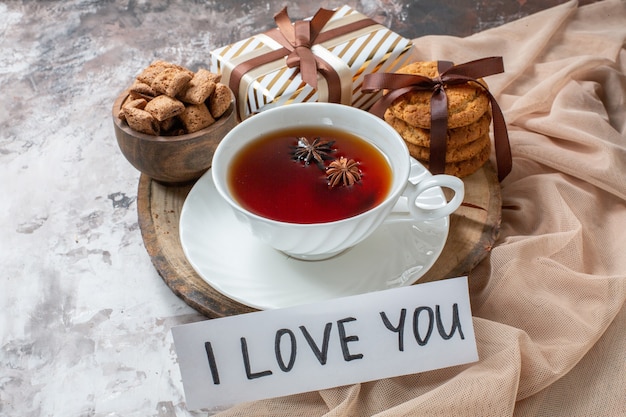 Foto gratuita biscotti di zucchero vista frontale con una tazza di tè su sfondo chiaro biscotto da tè torta torta dolce pasticceria zucchero amore